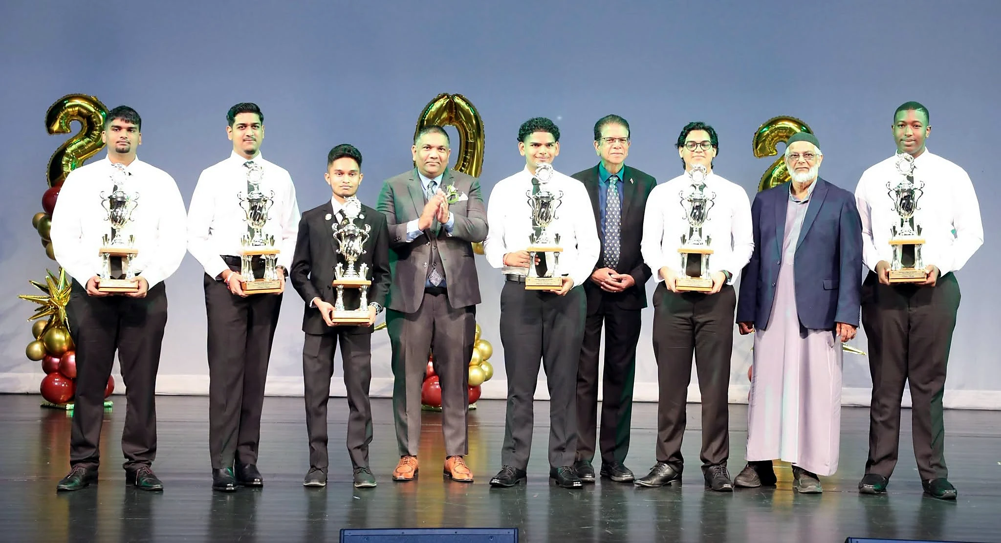 Awardees standing with trophies and school representatives